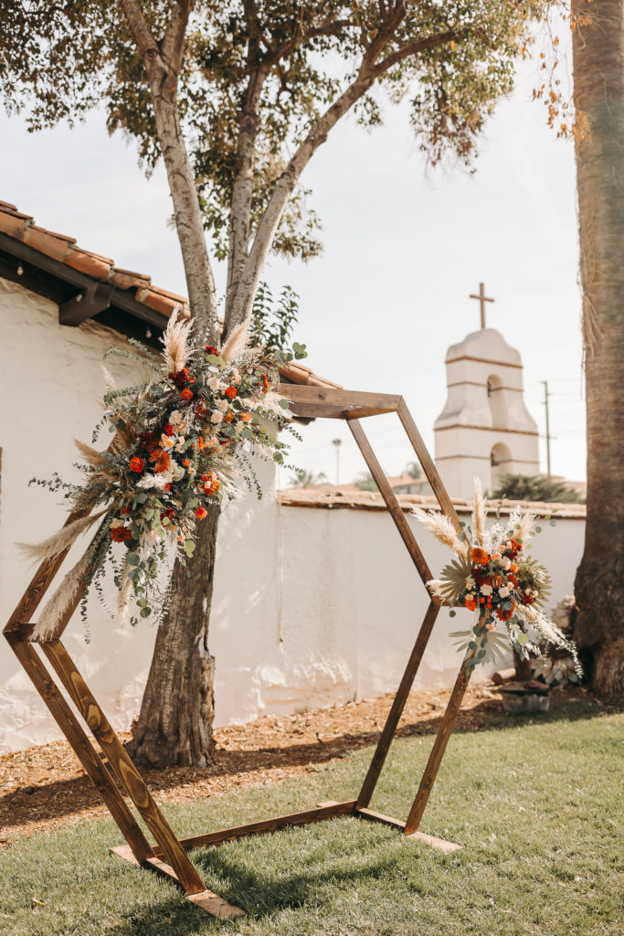 Hexagonal wedding backdrop with the asistencia bell tower in the background