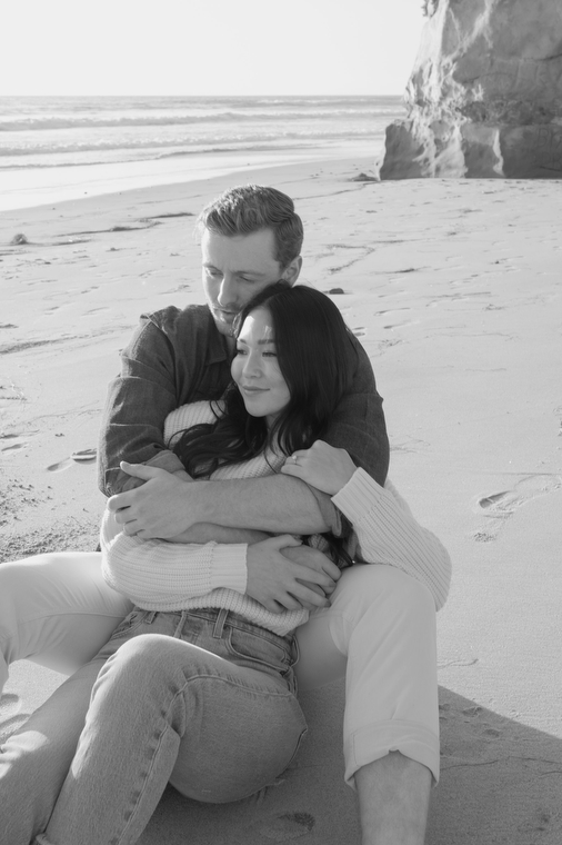 black and white photo of a couple embracing on the beach