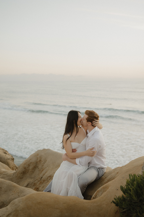 couple kissing on the cliff at the beach