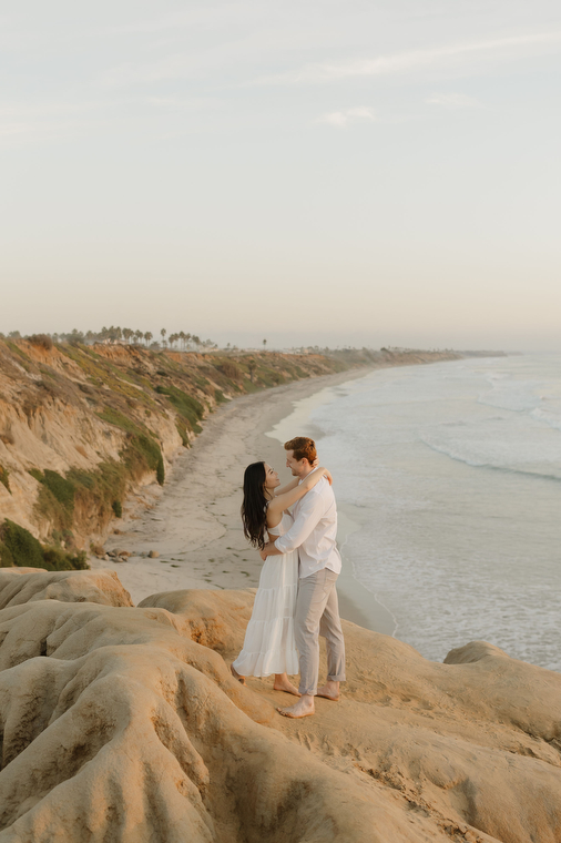 couple on the edge of a cliff at the beach