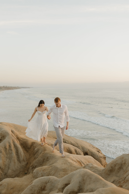 Couple holding hands on beach cliffs