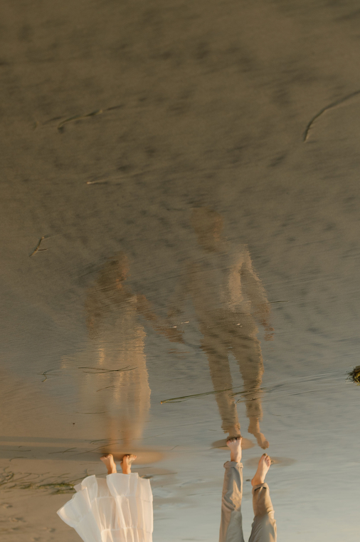 reflection of a couple on the beach water
