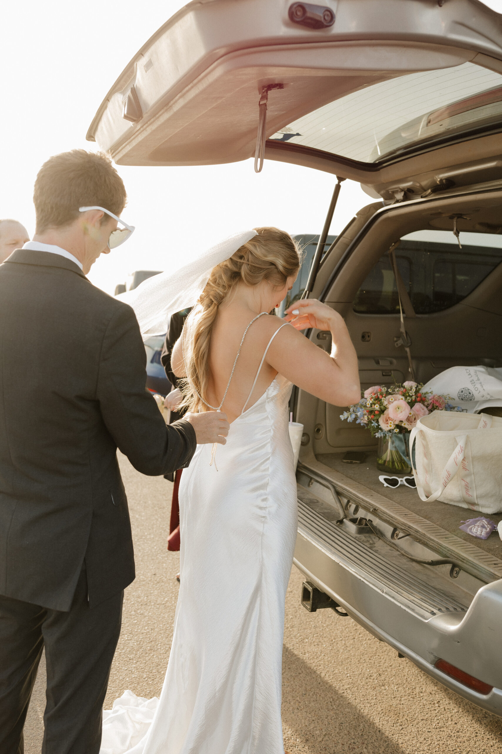 Groom helping the bride get dresses