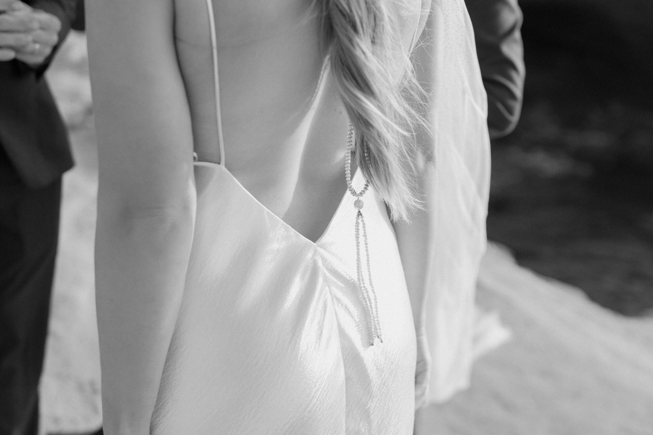 black and white closeup of brides back jewelery