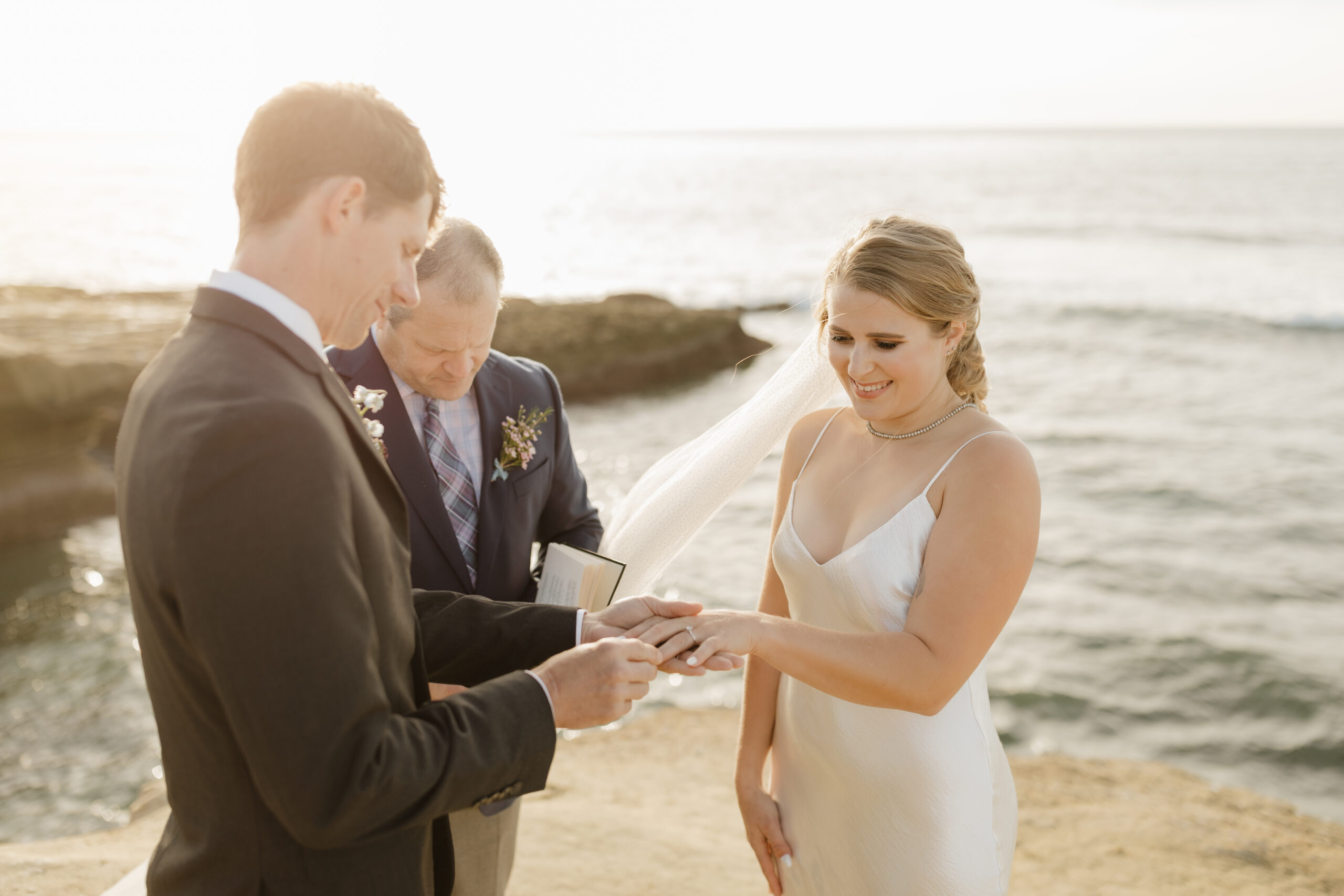 Groom putting ring on bride