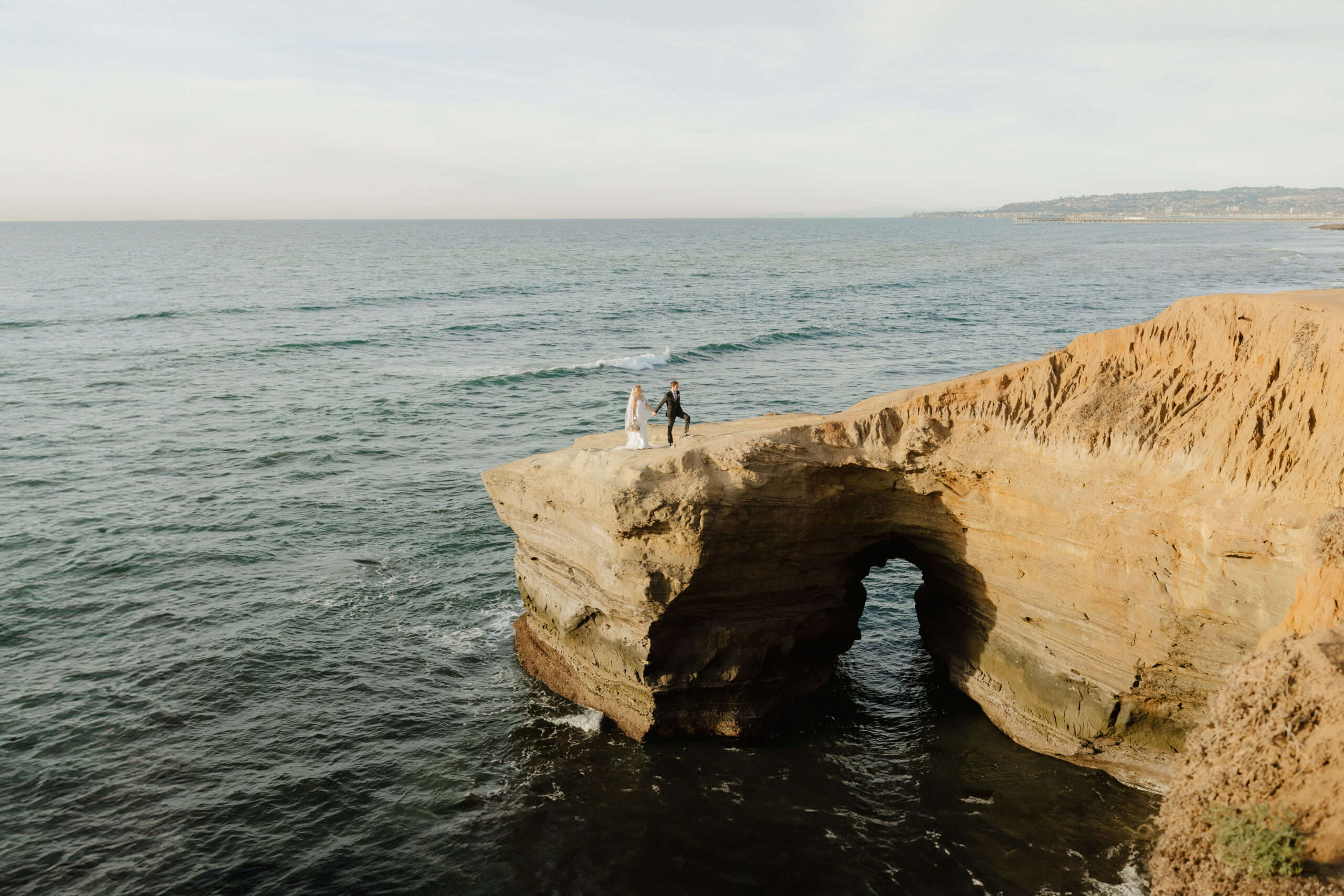 Couple on sunset cliffs archway