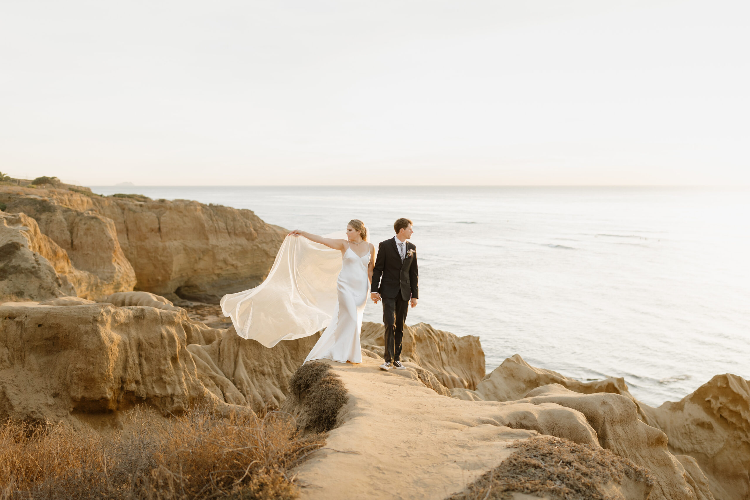 Couple walking while veil blows in the wind