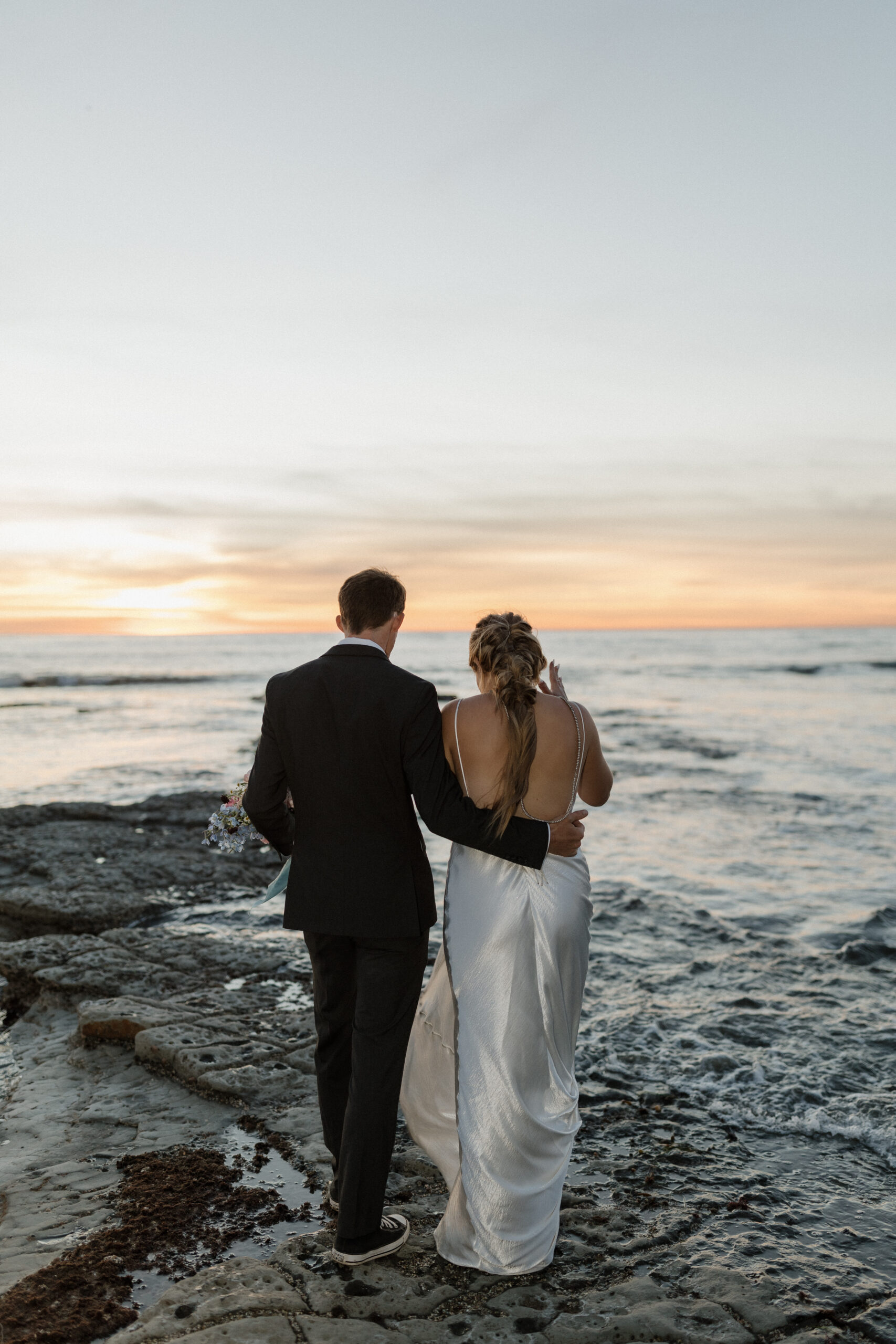 Groom with arm around brides back