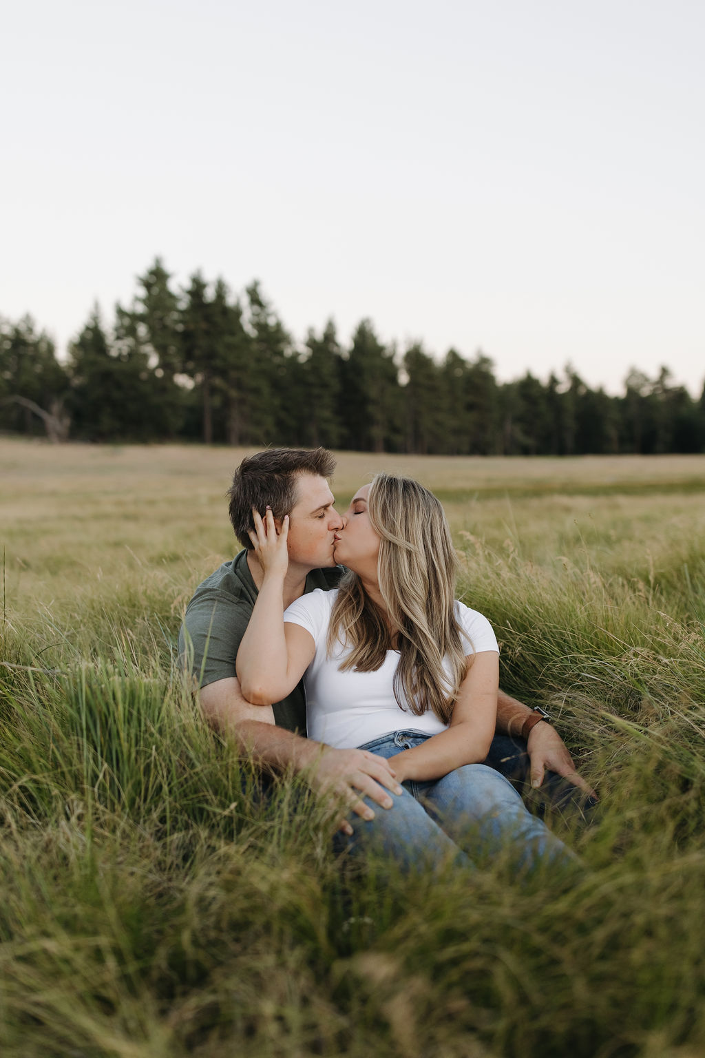 Couple kissing while sitting in a field