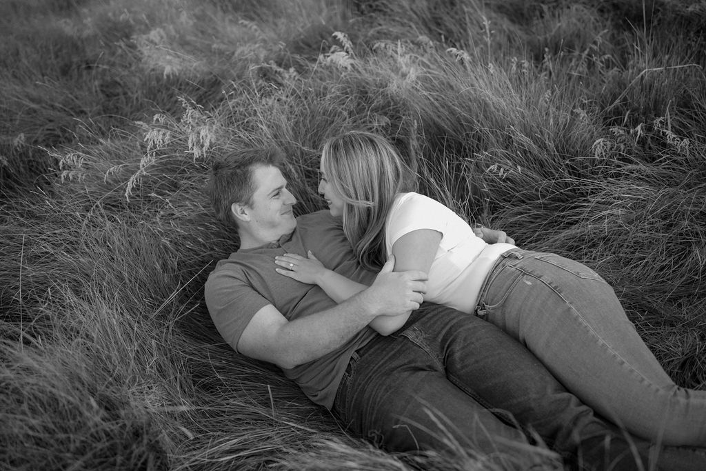 Couple laying in tall grassy field