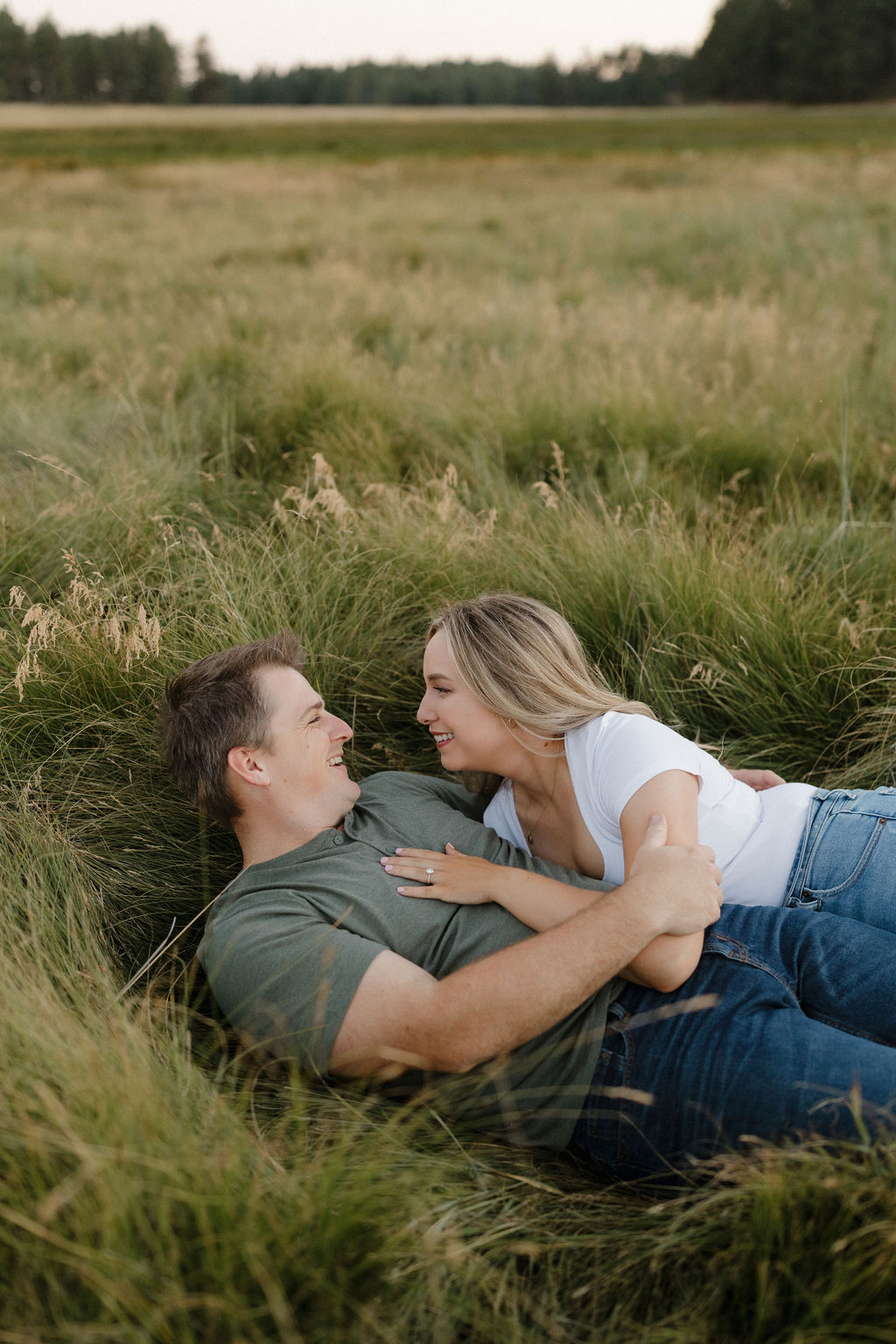 Couple laying in tall grassy field