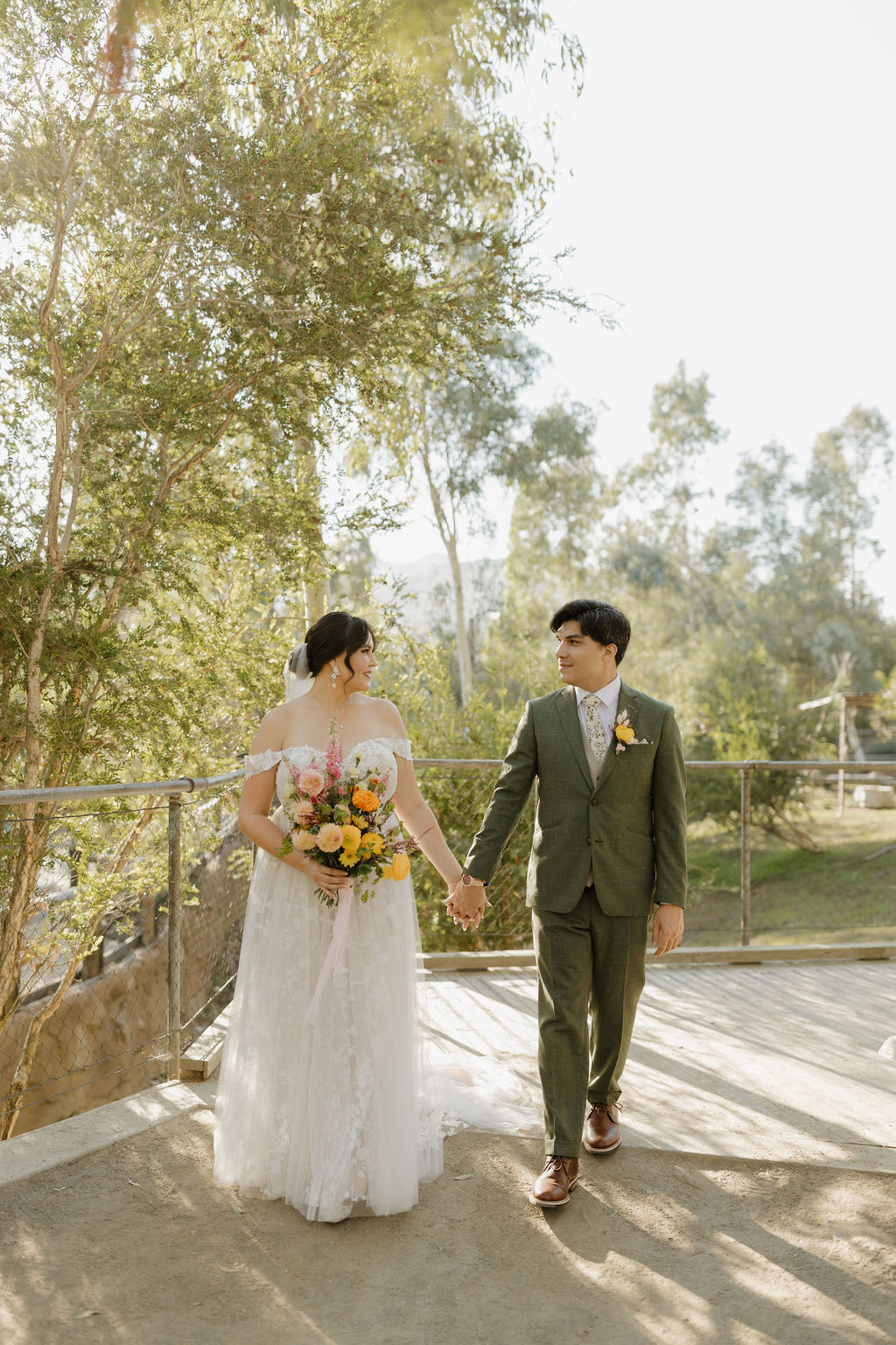 Wedding couple walking through the Wallaby exhibit at the San Diego Zoo Safari Park.