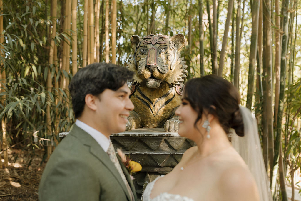 Tiger statue behind the wedding couple as they explore the SD zoo safari park. 