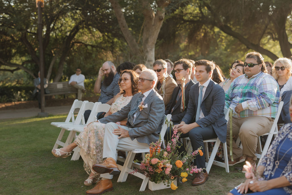 Guests at a wedding watching the bride and groom get married. 