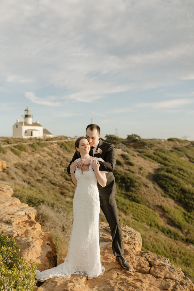 Couple embracing along the cliffs after Cabrillo National Monument wedding
